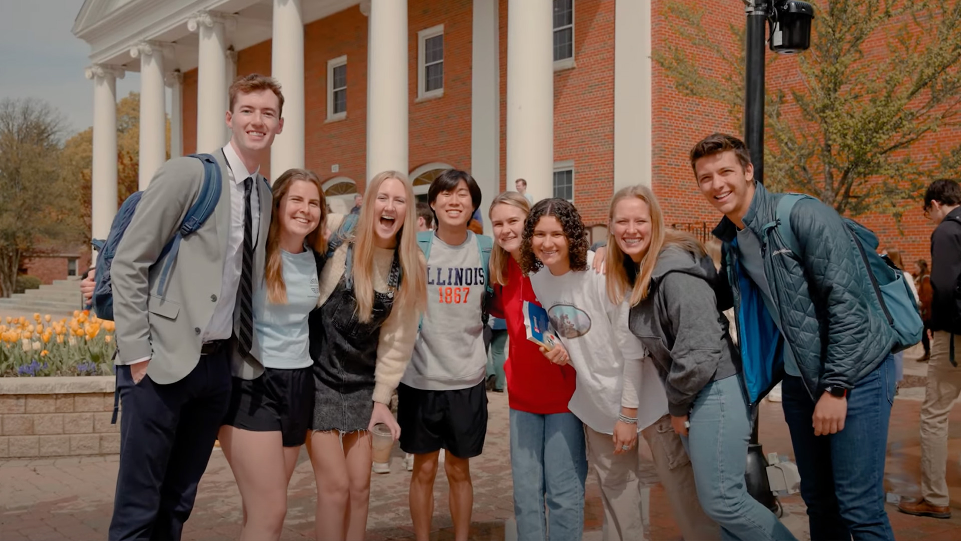 A group of students pose for a student in the center of Wheaton College's campus.